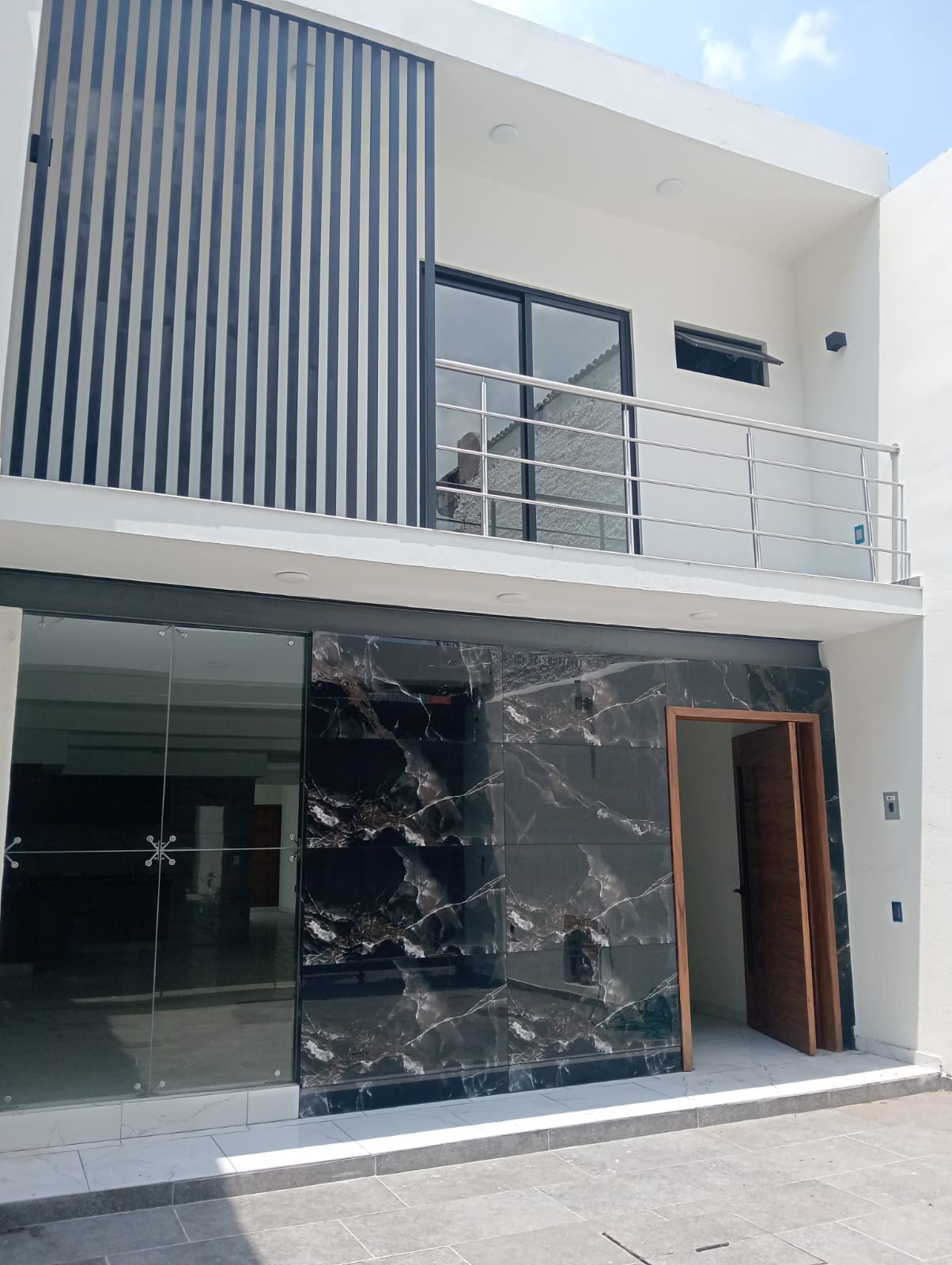Balcón con barandal de acero inoxidable en fachada
